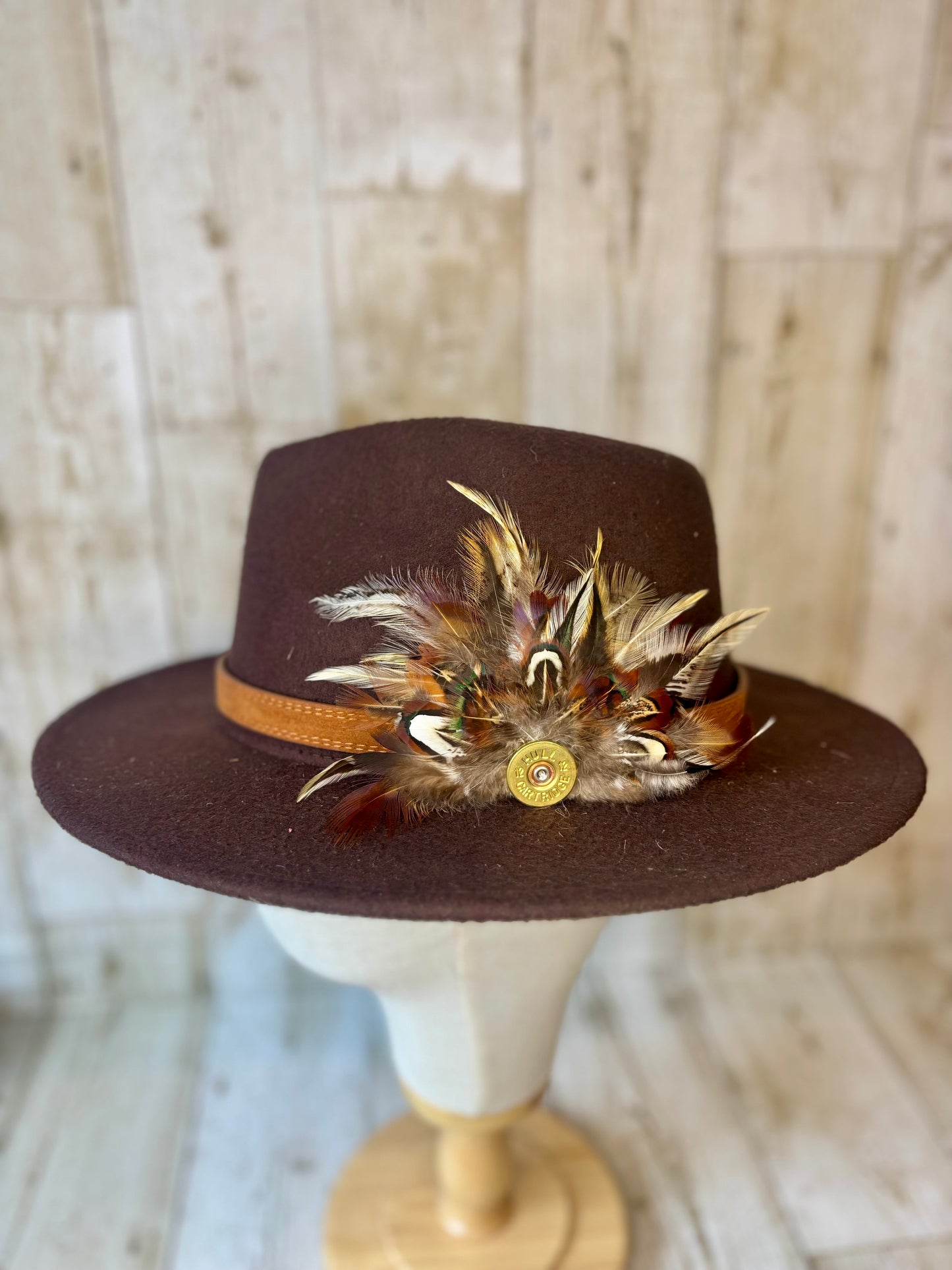 Pheasant feather hat pin with cartridge end.