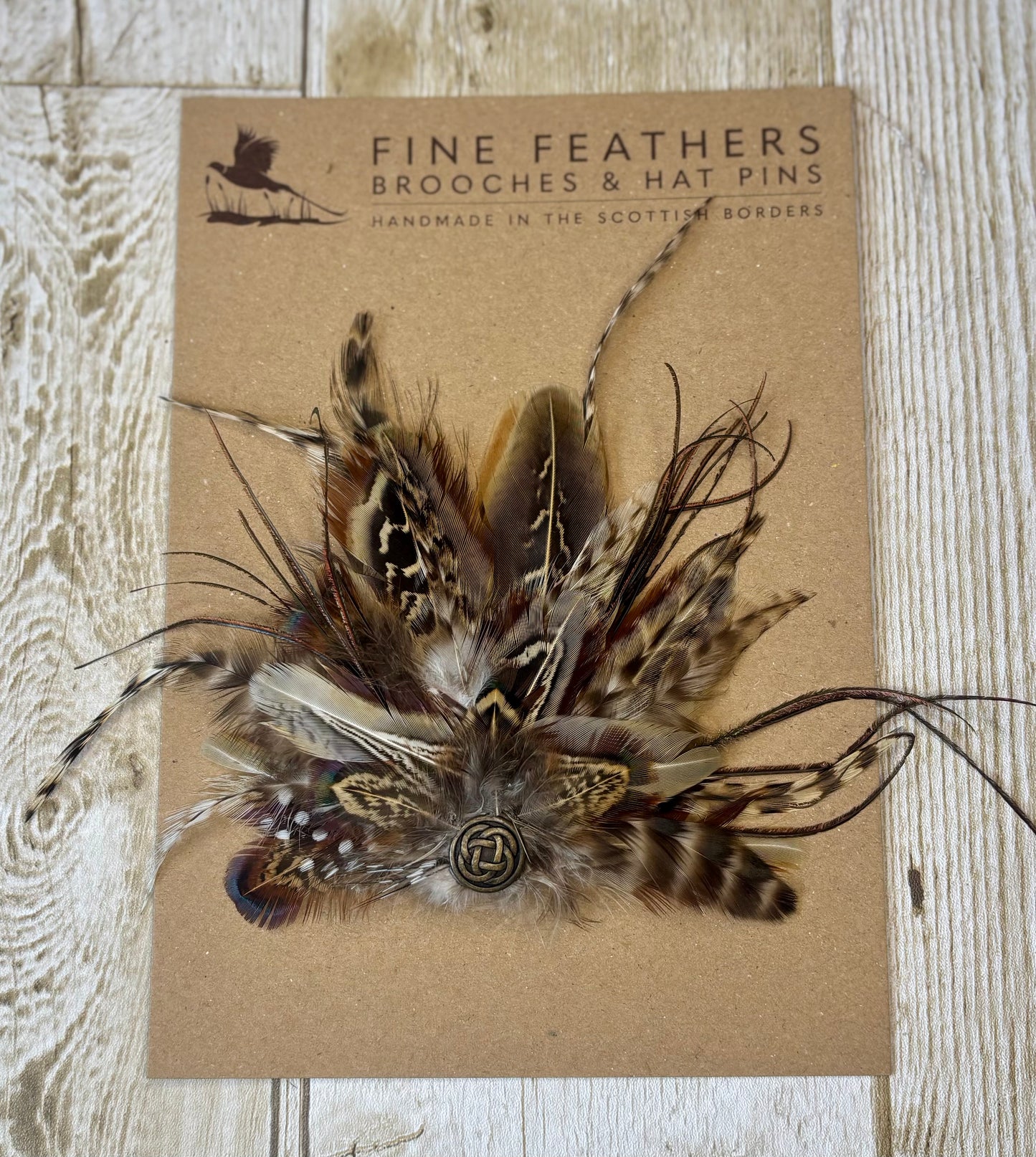 Pheasant feather hat pin with Celtic button.