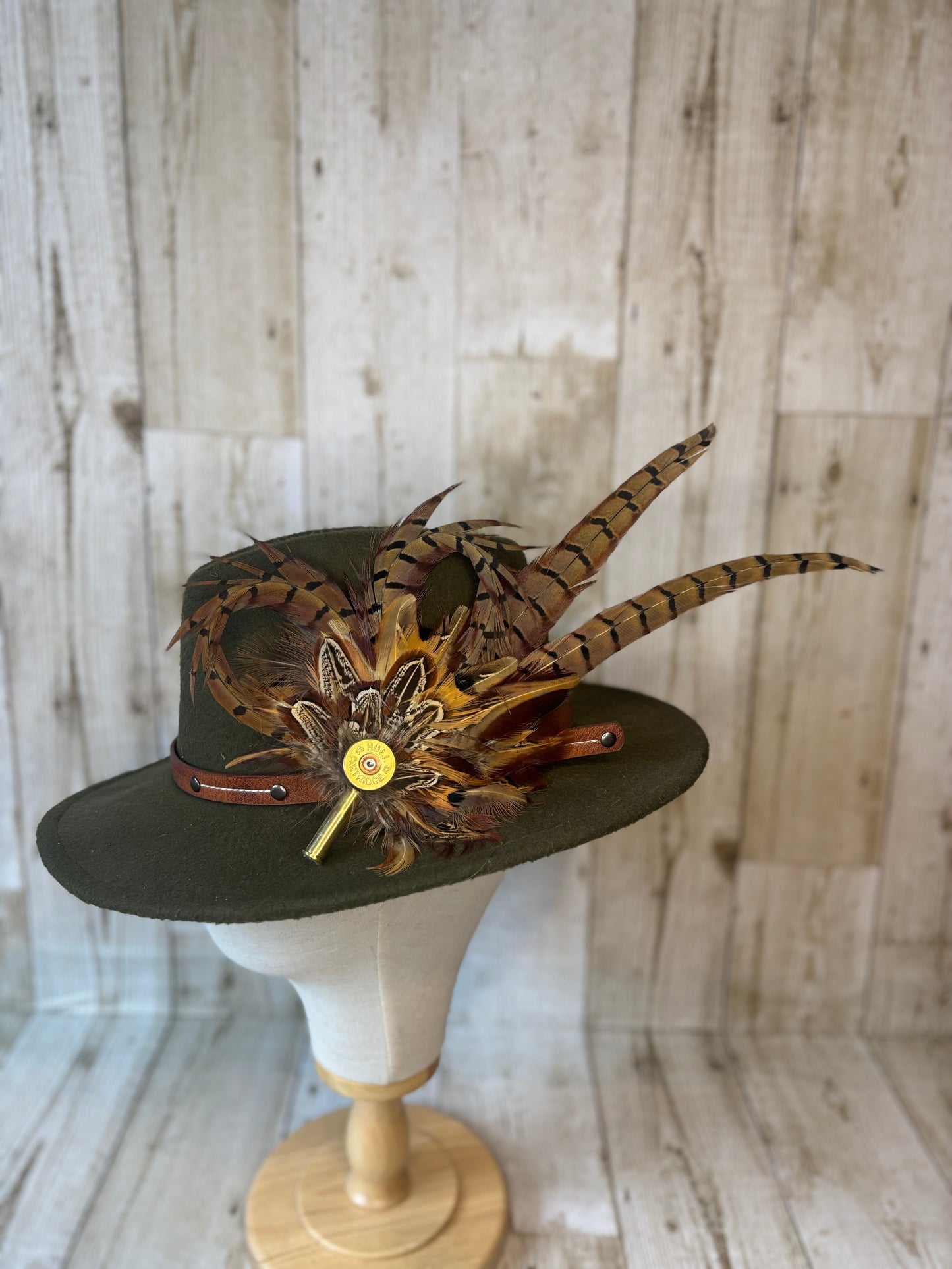 Pheasant feather hat pin with cartridge end and shell casing.