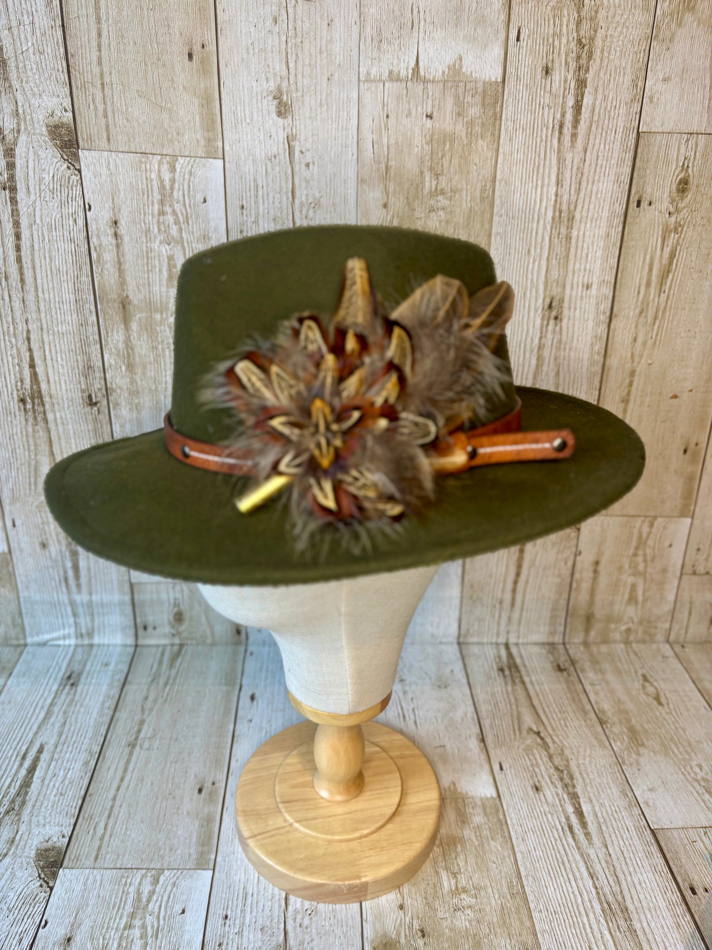 Pheasant feather hat pin with brass casing.